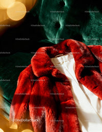 Luxurious red fur coat on emerald green velvet sofa