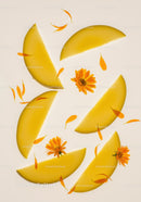 Fresh yellow melon slices with calendula flowers overhead
