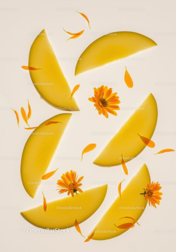 Fresh yellow melon slices with calendula flowers overhead