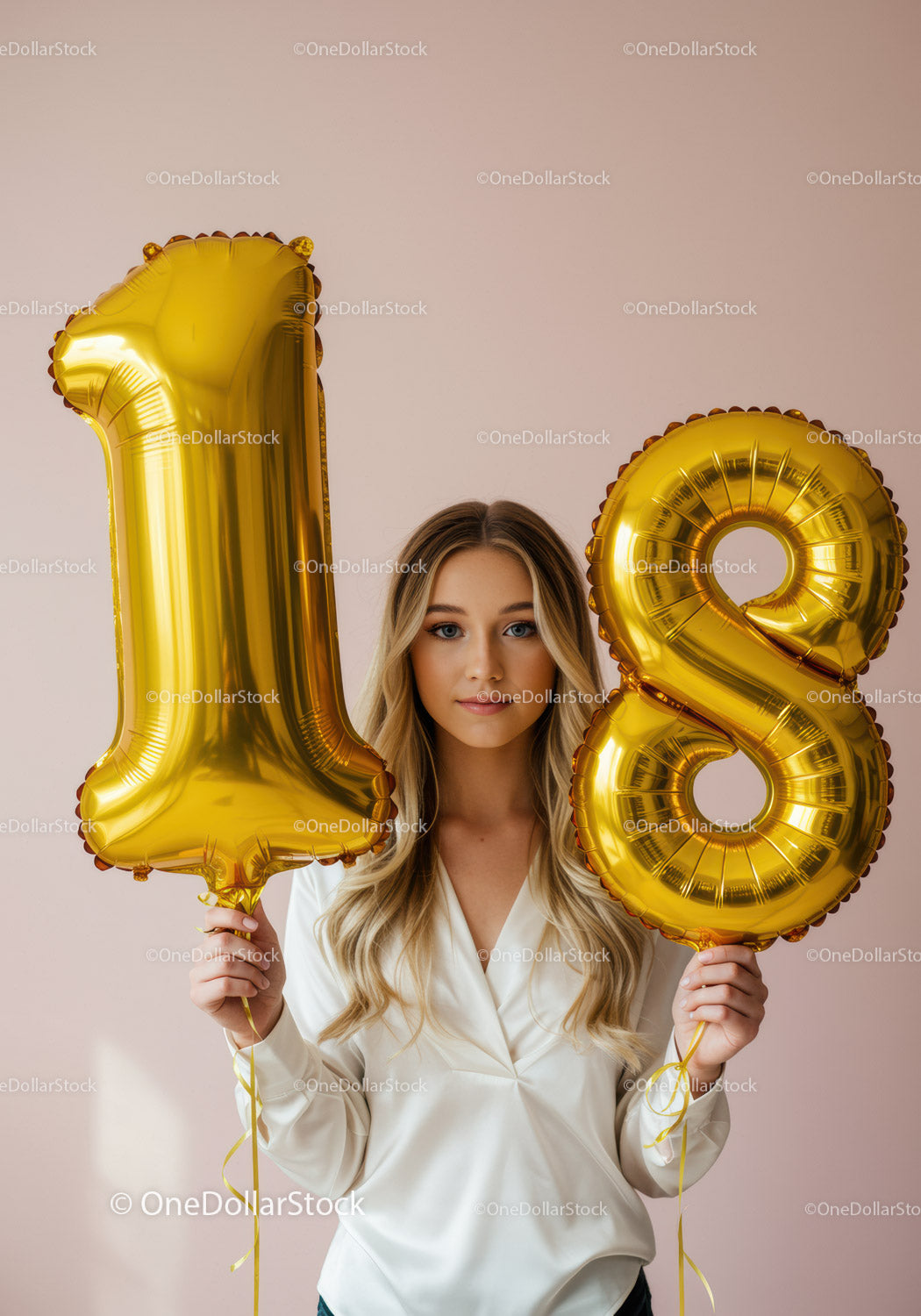Young woman celebrating 18th birthday with golden balloons