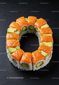 Fresh salmon and avocado sushi ring on black slate