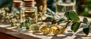 Herbal Essential Oils in Glass Bottles with Green Leaves on Wooden Surface