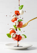 Fresh Caprese Salad Ingredients Falling with Balsamic Drizzle