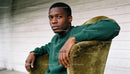 Thoughtful young man sitting on vintage chair indoors