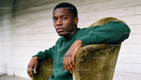 Thoughtful young man sitting on vintage chair indoors