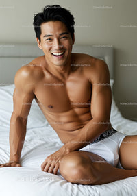 Happy shirtless man relaxing on white bed at home