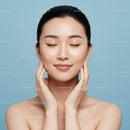 Young Woman with Flawless Skin Relaxing Against Light Blue Background