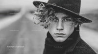 Young Man with Curly Hair and Black Hat in Monochrome Portrait