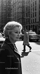 Elderly Woman in Busy City Street Surrounded by Vintage Cars