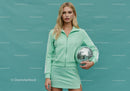 Young Woman in Mint Green Tracksuit Holding Disco Ball in Studio