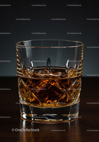 Elegant Crystal Whiskey Glass with Amber Liquor on Wooden Surface