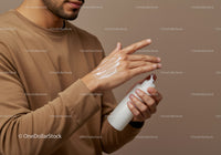 Man Applying Lotion for Hand Care in a Minimalist Setting