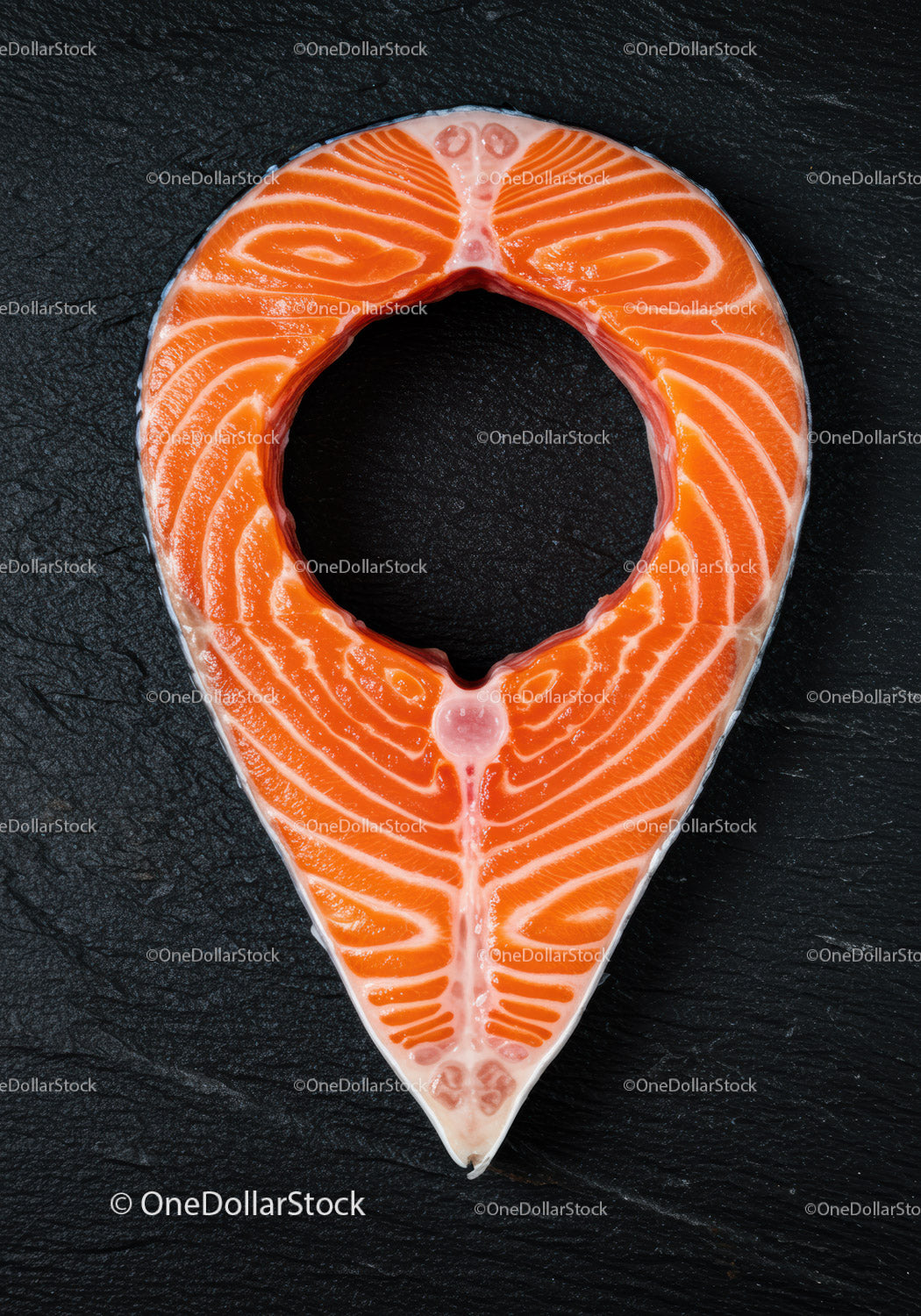 Fresh salmon steak on dark textured surface