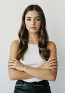 Portrait of a Stylish Young Woman with Crossed Arms and Confident Expression