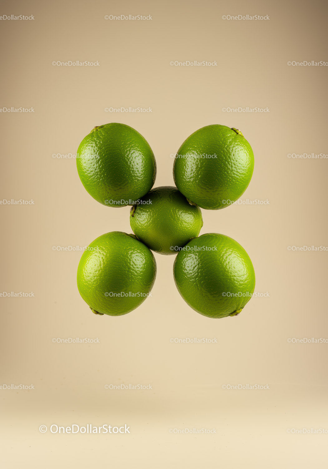 Fresh green limes arranged in circular formation on beige