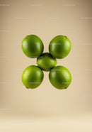 Fresh green limes arranged in circular formation on beige