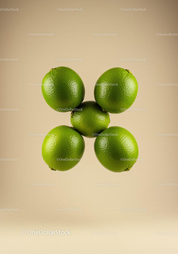 Fresh green limes arranged in circular formation on beige