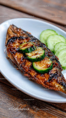 Grilled Fish with Cucumber Slices on White Plate on Wooden Table