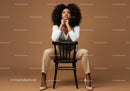 Stylish Woman with Curly Hair Sitting on a Chair in a Studio Setting