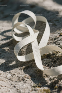 White Ribbon Stranded on Sandy Beach with Ocean View