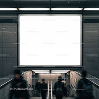 Commuters descending stairs under blank urban billboard