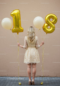 Young woman in lace dress holding 18th birthday balloons