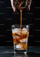 Pouring Cold Brew Coffee over Ice in Clear Glass