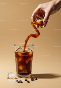 Pouring cold brew coffee with ice cubes in glass