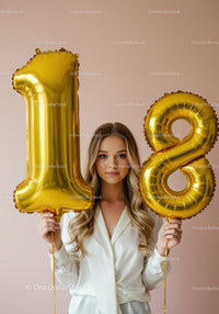 Young woman celebrating 18th birthday with gold balloons