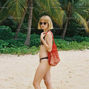 Woman in Bikini with Red Tote Bag on Tropical Beach with Palm Trees