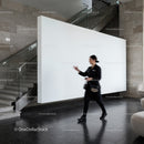 Blurred woman walking past modern white wall indoors