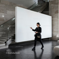 Blurred woman walking past modern white wall indoors