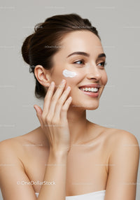 Young Woman Applying Face Cream for Glowing Skin