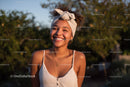 Happy Young Woman Wearing Headscarf and Jewelry Outdoors