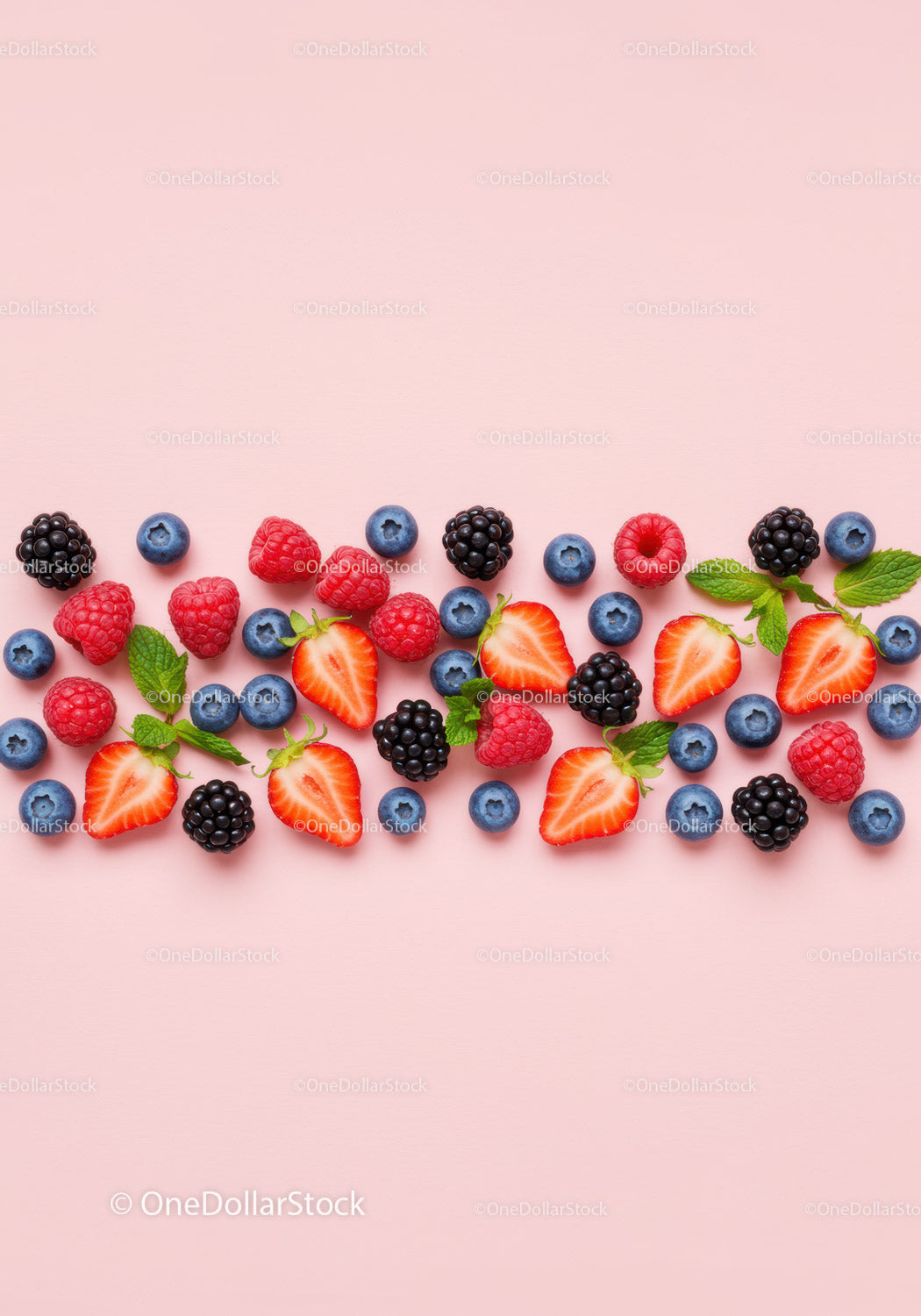 Fresh mixed berries with mint leaves on pink background