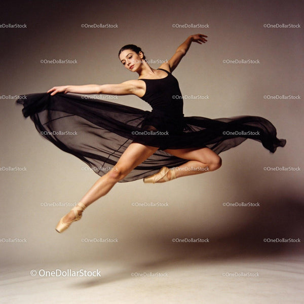 Graceful ballerina performing a high jump in black tutu