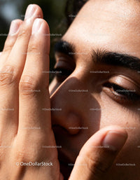 Close-up of man covering half face with hand