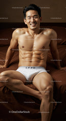 Fit man relaxing on bed in white underwear