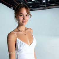 Young Woman in White Dress Smiling in Professional Studio Setting