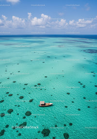 Stunning Turquoise Ocean with Reef and Boat Under Blue Sky