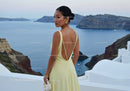 Elegant woman in yellow dress overlooking sea cliffs