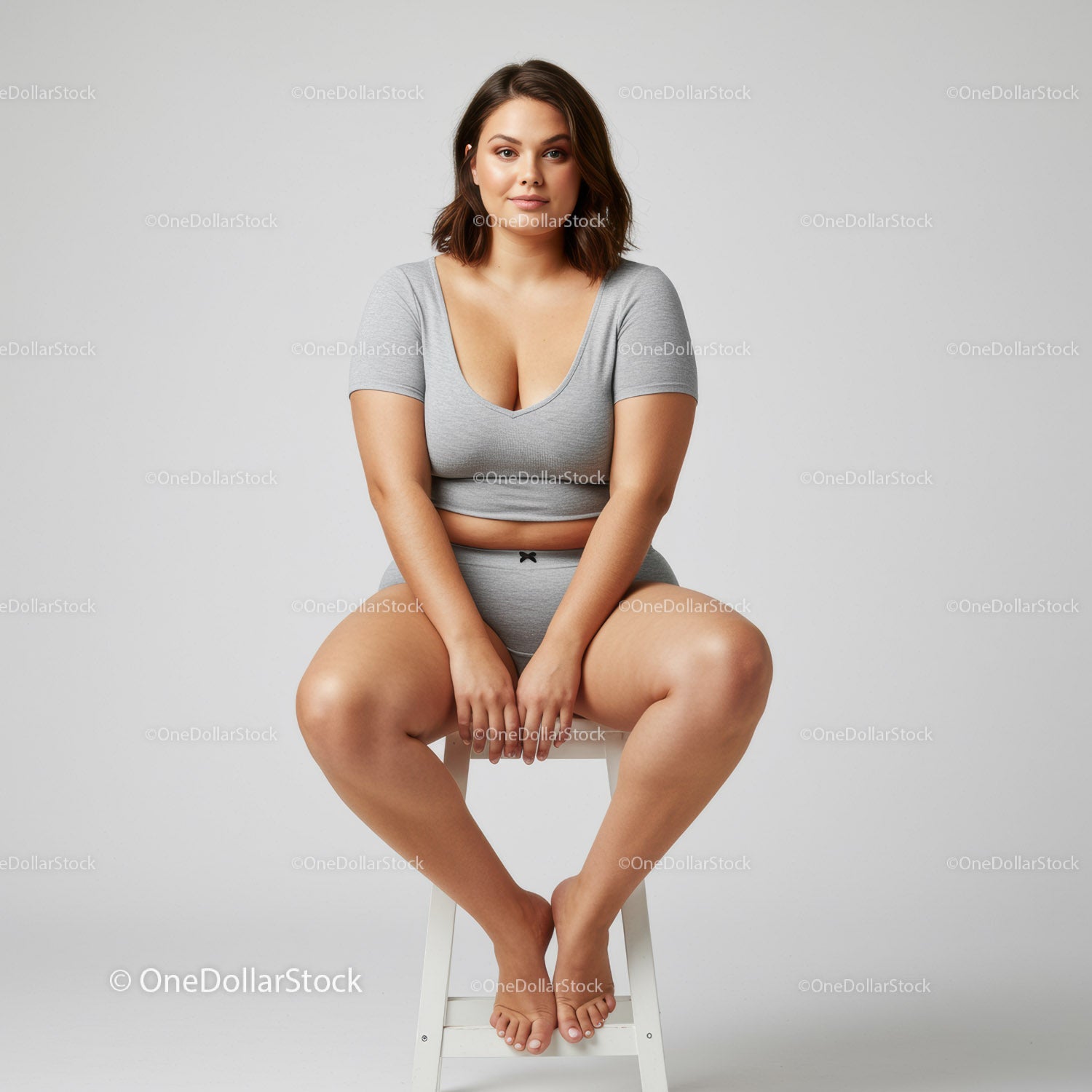 Confident Woman Sitting on Stool Wearing Casual Gray Outfit