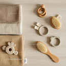 Neutral toned baby care essentials on wooden surface