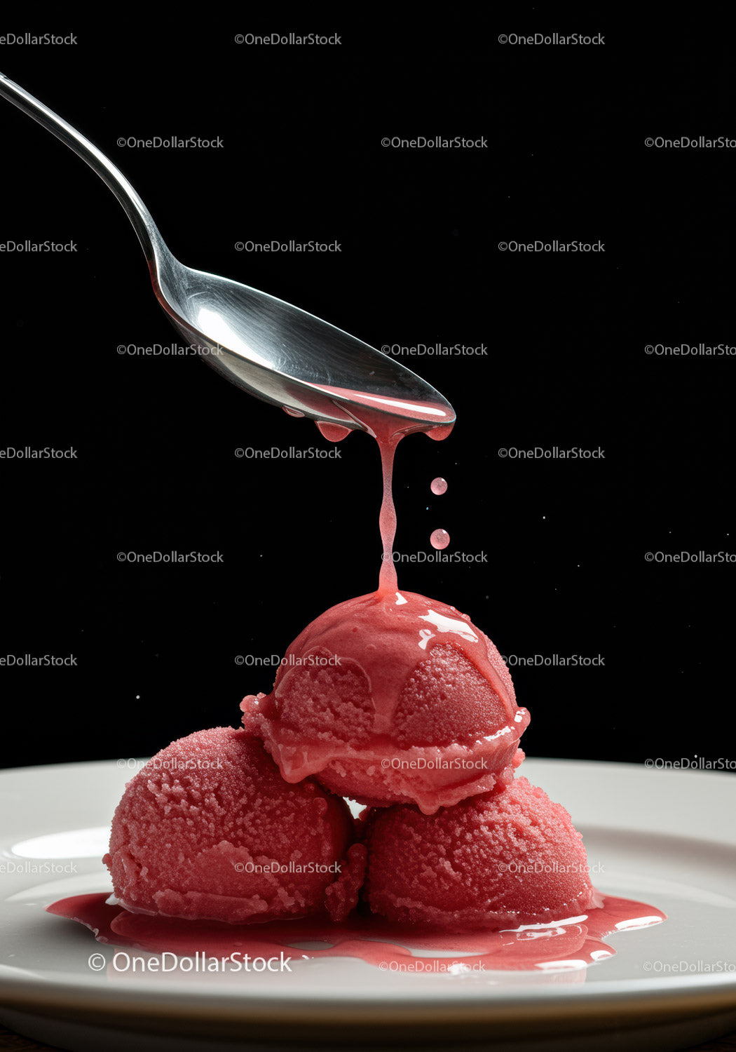 Three scoops of raspberry sorbet with sauce drizzle