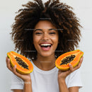 Young Woman Holding Halved Papayas with Bright Smile