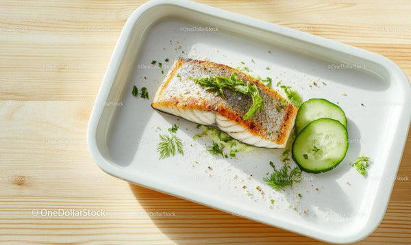 Świeży grillowany filet z ryby z plasterkami ogórka na białym talerzu