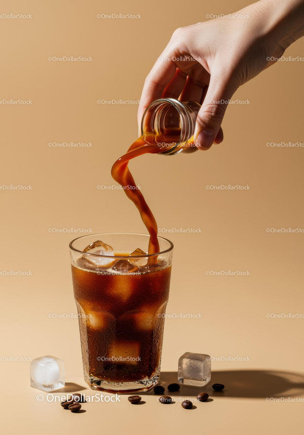 Pouring Cold Brew Coffee Over Ice Cubes in Clear Glass