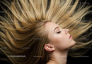 Blonde woman with flowing hair against dark background