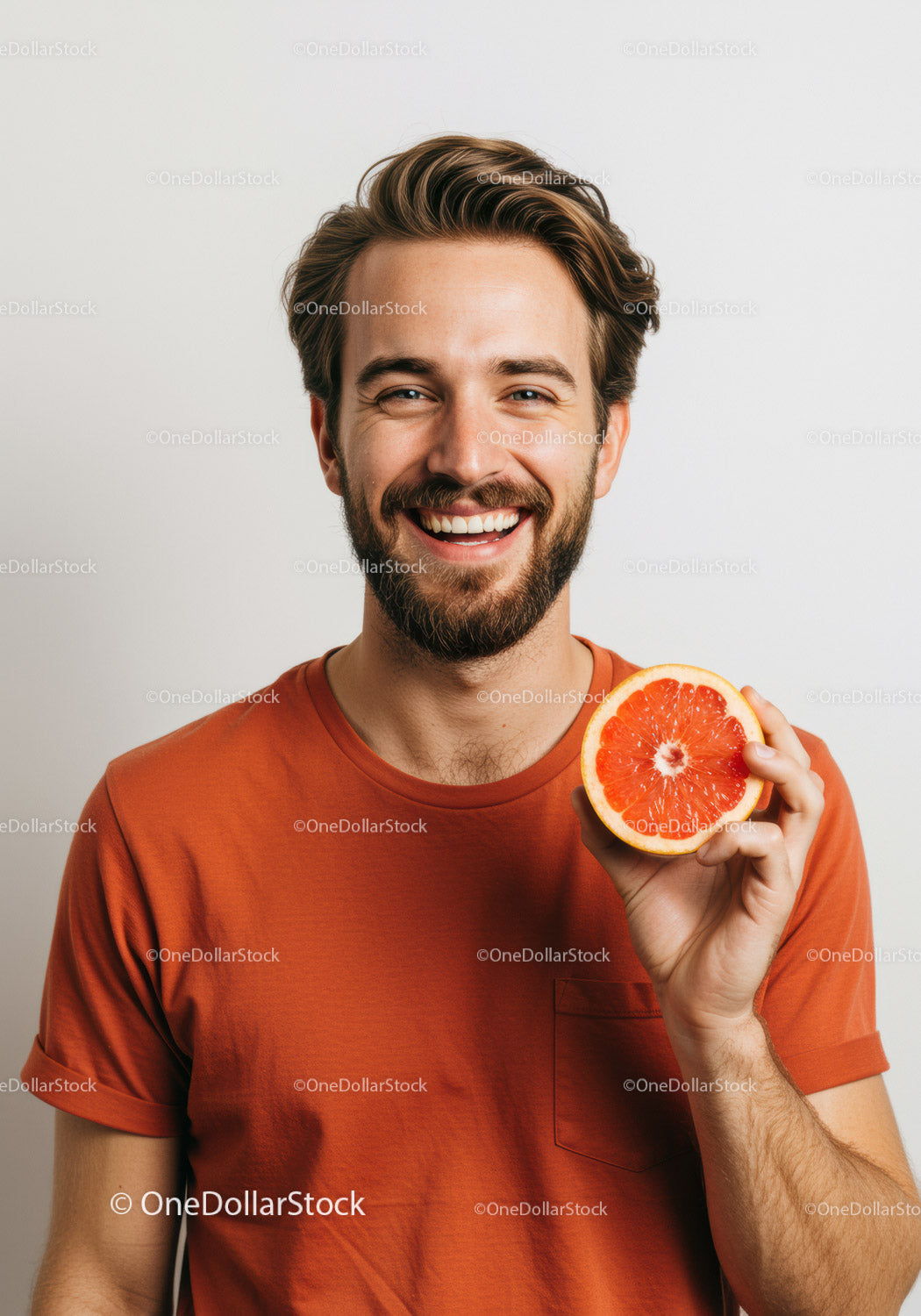 Smiling Man in Orange T-Shirt Holding Juicy Grapefruit for Fresh Summer Lifestyle