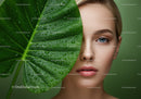 Close-Up of Woman with Blue Eyes Behind Large Green Leaf with Dew Drops